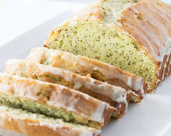 A close up view of a glazed lemon poppy seed loaf cut into slices. — Stock Photo, Image