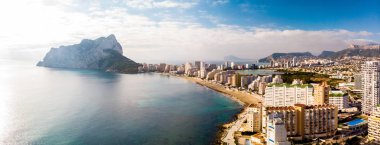 İspanya 'nın Alicante kentindeki Calpe şehrinin gündoğumunda havadan görüntüsü. La Fossa plajı ön planda ve de Ifach Penon kayası arka planda..