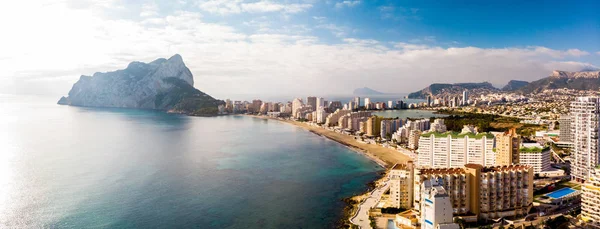 İspanya 'nın Alicante kentindeki Calpe şehrinin gündoğumunda havadan görüntüsü. La Fossa plajı ön planda ve de Ifach Penon kayası arka planda.. — Stok fotoğraf