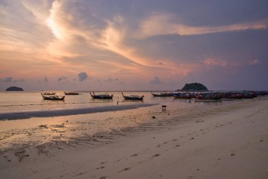 Tekne ya da taksi, güneş ve bulutlarla dolu bir yaz gününün günbatımında Tayland sahilinde demirlemişti. Ayrıca Uzunkuyruk olarak da bilinir..