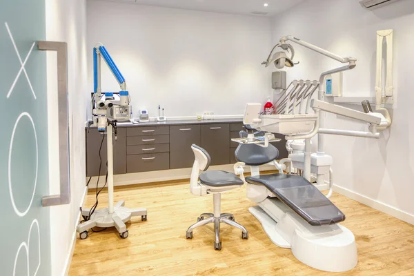 Tam donanımlı, beyaz duvarları ve ahşap döşemeleri olan modern diş kliniği kutusu.