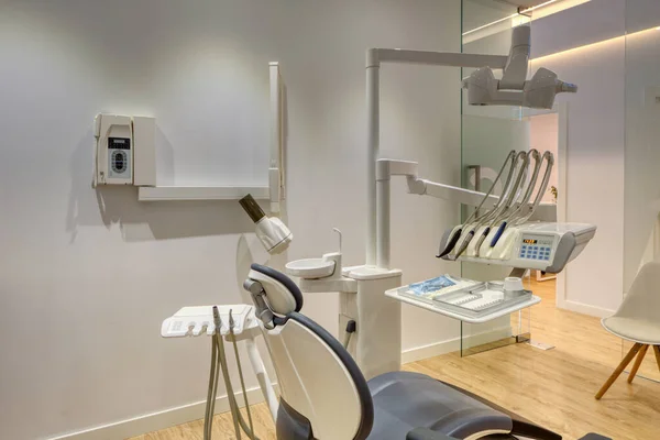 Tam donanımlı, beyaz duvarları ve ahşap döşemeleri olan modern diş kliniği kutusu.
