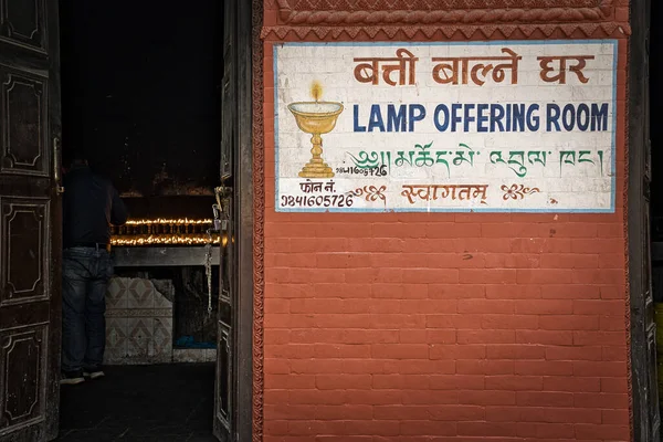 Entré till lampa erbjuder rum i Nepal, Asien med handmålade skyltar på väggen av röda tegelstenar. — Stockfoto