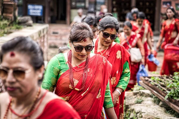 Des femmes hindoues en ligne vêtues de rouge et de lunettes de soleil célébrant la fête Raksha Bandhan Yatra en août 2019, Patan. Népal . — Photo
