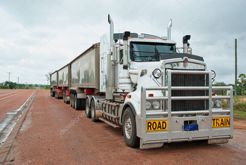 Super long goods truck used for long freight transport in Australia. Called road train for how long they are. Can measure more than 50 meters longSuper long white goods truck with three containers. Us
