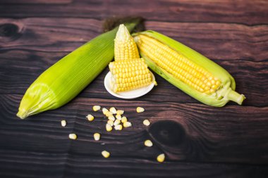 Tahta masadaki koçanlarda taze mısır, yakın plan, üst manzara.