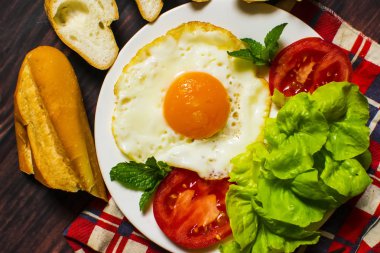 Ekmek, kızarmış yumurta, süt ve sebze ve ahşap arka plan üzerinde kızarmış domates adet ile Kahvaltı