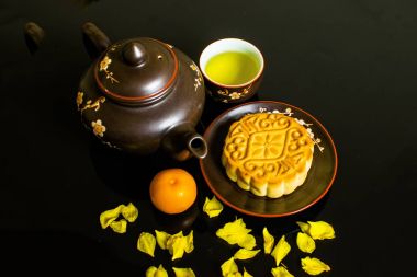 Mooncake ve çay, Çin orta Sonbahar Festivali gıda üzerinde izole siyah arka plan.