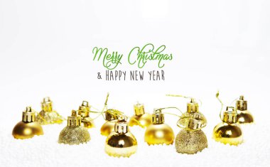 Noel kartı, altın takılar, toplar, dekorasyonlar, gümüş beyaz arka planda bulanık, bulanık, aydınlık (bokeh), yumuşak, nötr, sıcak renkler ve mutlu noel yazıları içeren süsler.