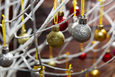 Tahtadaki Noel ağacından sarkan renkli toplar.