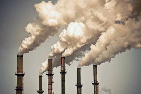 Nuvole di fumo sopra camini di fabbrica Foto Stock