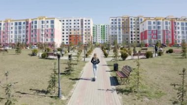 Kız koruyucu maskeli, elektrikli scooter kullanıyor.