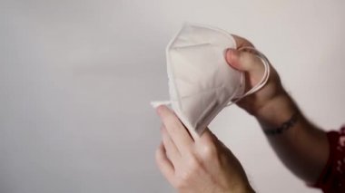 Ellerindeki solunum cihazı beyaz bir arkaplanı kapatıyor.