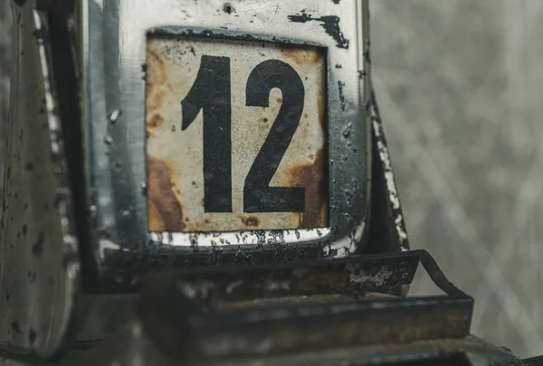 Day 12 number on metal rusty vintage calendar. Bad day concept.