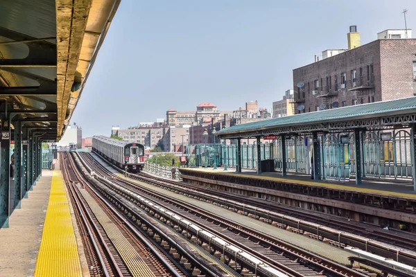 Train arriving at the station in New York City. Buildings in the background, cityscape. Travel and transit concept. Manhattan, NYC, USA — Stock Photo, Image