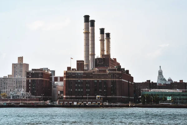 Bureaux, appartements et cheminées industrielles bâtiments dans l'horizon au coucher du soleil, de la rivière Hudson. Pollution et concept industriel. Manhattan, New York, États-Unis . — Photo