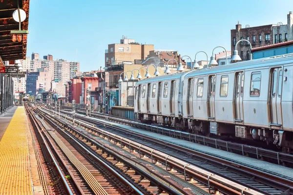 Train arriving at the station in New York City. Buildings in the background, cityscape. Travel and transit concept. Manhattan, NYC, USA — Stock Photo, Image