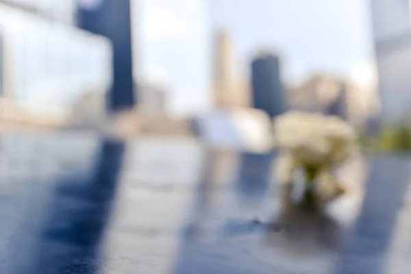 Sıfır Bölge anıtının kavramsal fotoğrafları. Ön planda çiçek ve arka planda odaklanmamış binalar. Manhattan, New York, Usa