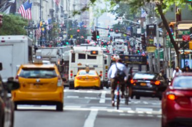 New York 'taki hayatın çılgın aktivitesinin bulanık konsepti. Arabalar, toplu taşıma araçları, bisikletçiler, yayalar, binalar, tabelalar ve bayraklar. Kalabalık şehir ve trafik kavramı. Manhattan, New York
