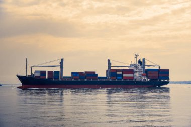 Akşam ışığında konteynır taşıyan kargo gemileri. Ulaşım ve deniz ticareti kavramı. Lizbon, Portekiz. Avrupa