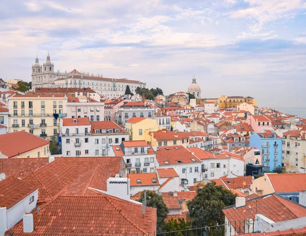 Lisbon panoramic view. Colorful walls of the buildings of Lisbon, with orange roofs and the Church of Sao Vicente of Fora in the background. Sunny dayand blue sky in summer. Travel and real estate con — Stock Photo, Image