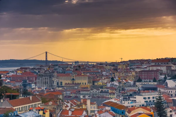 Lisbon panoramic view. Colorful walls of the buildings of Lisbon, with orange roofs and the 25th of April bridge in the background, at sunset. Travel and real estate concept. Lisbon, Portugal. Europe. — Stock Photo, Image