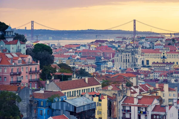 Lisbon panoramic view. Colorful walls of the buildings of Lisbon, with orange roofs and the 25th of April bridge in the background, at sunset. Travel and real estate concept. Lisbon, Portugal. Europe — Stock Photo, Image