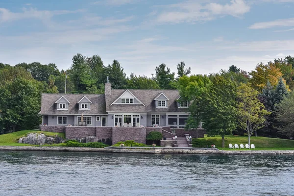 Gündüz vakti gölün kıyısında ağaçlarla çevrili çimenli bir alanda inşa ediliyor. Gayrimenkul kavramı. Binlerce Adalar. Ontario, Kanada.