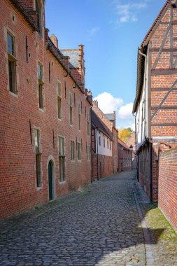 Güneşli bir günde Belçika 'nın Büyük Beguine şehrinden kırmızı tuğlalı binalarla dolu boş kaldırım taşlı caddeler. Seyahat kavramı.