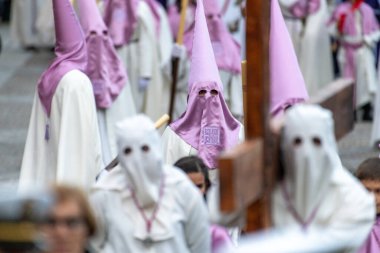 SALAMANCA, SPAIN - 18 Nisan 2019: Tipik İspanyol Kutsal Haftası sahnesi, tipik Paskalya şapkası takan, ve bir tanesinde dikenli taç ve ahşap haç taşıyan.