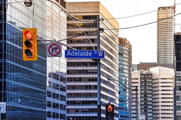 Adelaide Street sign, traffic signals, traffic lights and in the background, buildings in the Toronto financial district, at sunset. Business Concept. Toronto, Ontario, Canada