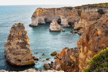 Yukarıdan doğal kemerlerin bakış açısına bak. - Evet. Turuncu kayalıklar ve turkuaz sular. Turizm ve seyahat kavramı. Algarve, Portekiz