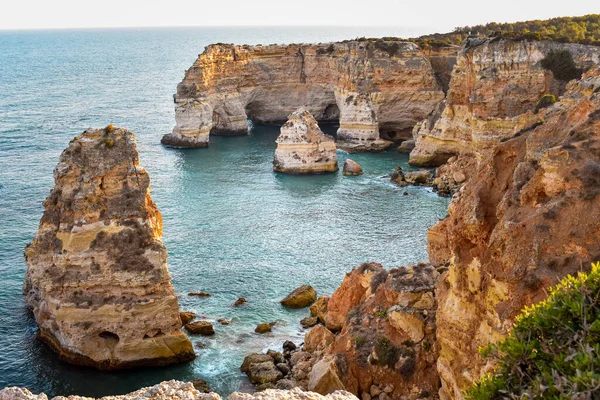 Yukarıdan doğal kemerlerin bakış açısına bak. - Evet. Turuncu kayalıklar ve turkuaz sular. Turizm ve seyahat kavramı. Algarve, Portekiz