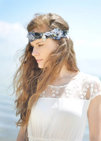 Kafasında aksesuar olan beyaz elbiseli kız.