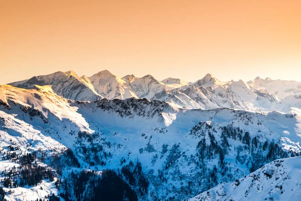 Winter snowy peaks of Alps. Mountain panorama illuminated by sunset at evening time. Austria and Switzerland, Europe — Stock Photo, Image