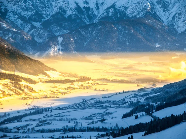 Manhã no vale alpino. Névoa de inverno iluminada por raios de sol nascente, Leogang, Áustria — Fotografia de Stock