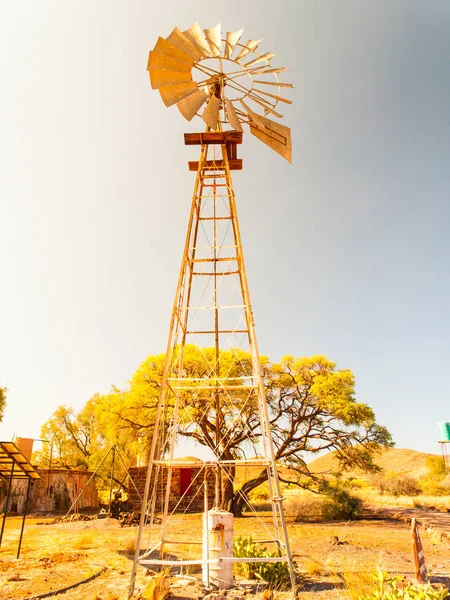 Stary wiatrak pompy wody w suchy krajobraz. Budowa wieży metalowe — Zdjęcie stockowe