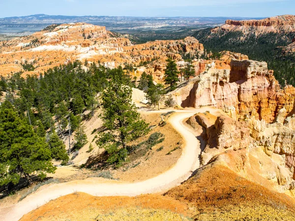 Napos Bryce Canyon, Utah, Amerikai Egyesült Államok. A sziklás völgyben, a zöld fák a poros országúton — Stock Fotó