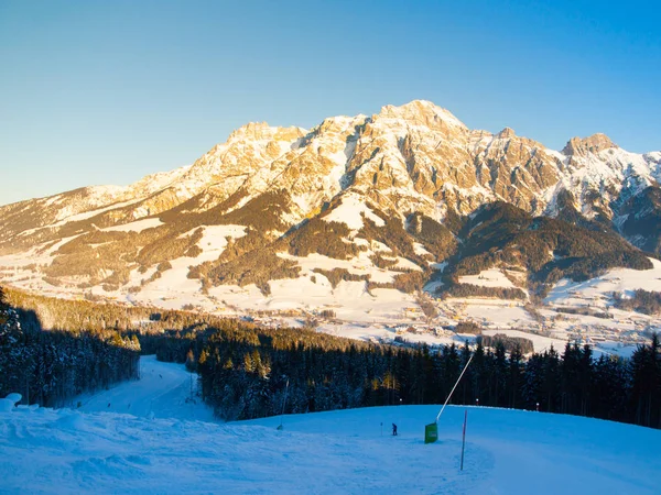 Sjezdovka v Evropě resort, Tirol, Rakousko, zimní Saalbach Hinterglemm Leogang. Slunečné ráno s jasnou oblohou a osvětlené horské masivní na pozadí — Stock fotografie