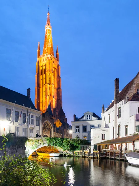 Iglesia de Nuestra Señora y puente sobre el canal de agua por la noche, Brujas, Bélgica —  Fotos de Stock