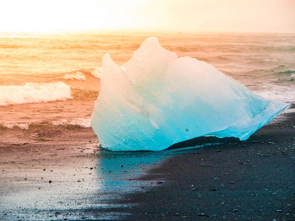Isberg sphashed av havets vågor på svarta strand, soluppgång tid nära glaciärlagunen glacier lake, Island — Stockfoto
