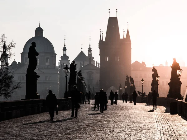 Mlhavé ráno na Karlově mostě, Praha, Česká republika. Východ slunce s siluety lidí, sochy a Staroměstské věže. Romantické cestování destinaci — Stock fotografie