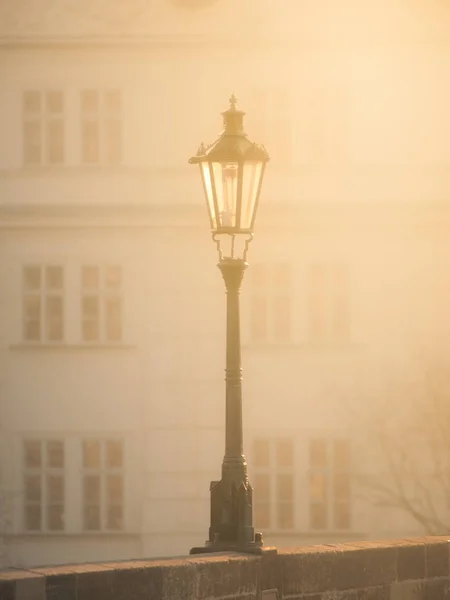 Lámpara de calle en el Puente de Carlos en la mañana brumosa, Praga, República Checa. Sepia imagen —  Fotos de Stock