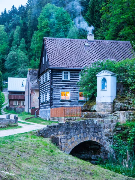 Antigua cabaña de madera tradicional con romántico con puente de piedra en el tiempo de la noche. Arquitectura rural checa — Foto de Stock