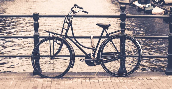 Altes fahrrad auf brücke über wasserkanal gesperrt, amsterdam, niederland — Stockfoto