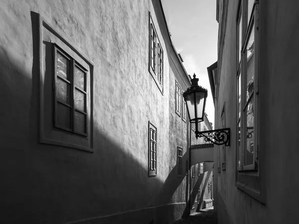 朝のプラハのシーン。ツノヴスカ通り、レッサー ・ タウン、プラハ、チェコ共和国ガス灯通り壁に太陽に照らされた、長い影 — ストック写真