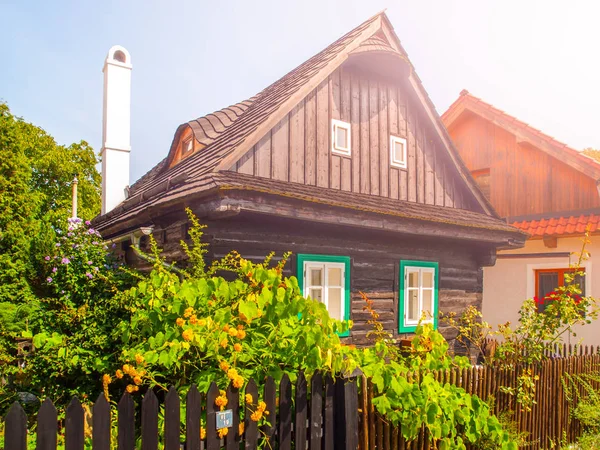 Antigua casa de madera tradicional con jardín de flores verde exuberante romántico e idílico con valla de madera en el día de verano soleado. Arquitectura rural de Moravia —  Fotos de Stock