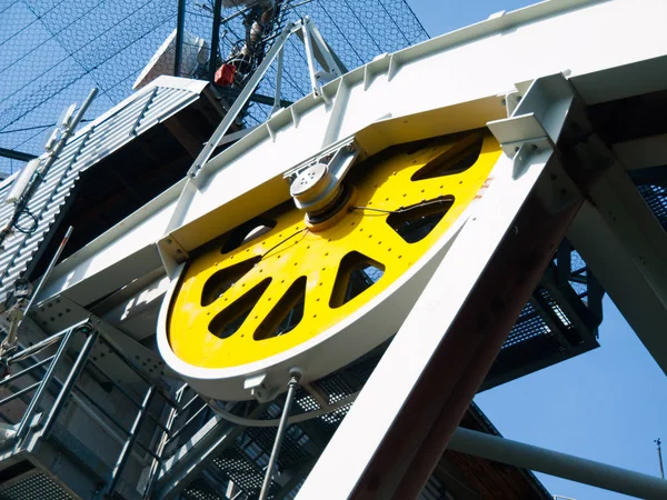 Close-up view of yellow steel giant wheel of cableway — Stock Photo, Image