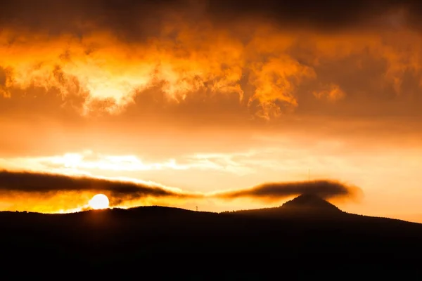 Jested Mountain gömd i molnen. Dramatiska röd himmel vid solnedgång. Liberec, Tjeckien — Stockfoto
