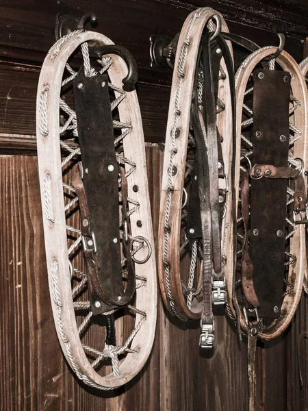 Vintage raquetas de nieve de madera colgando en la pared en casa de campo de montaña — Foto de Stock